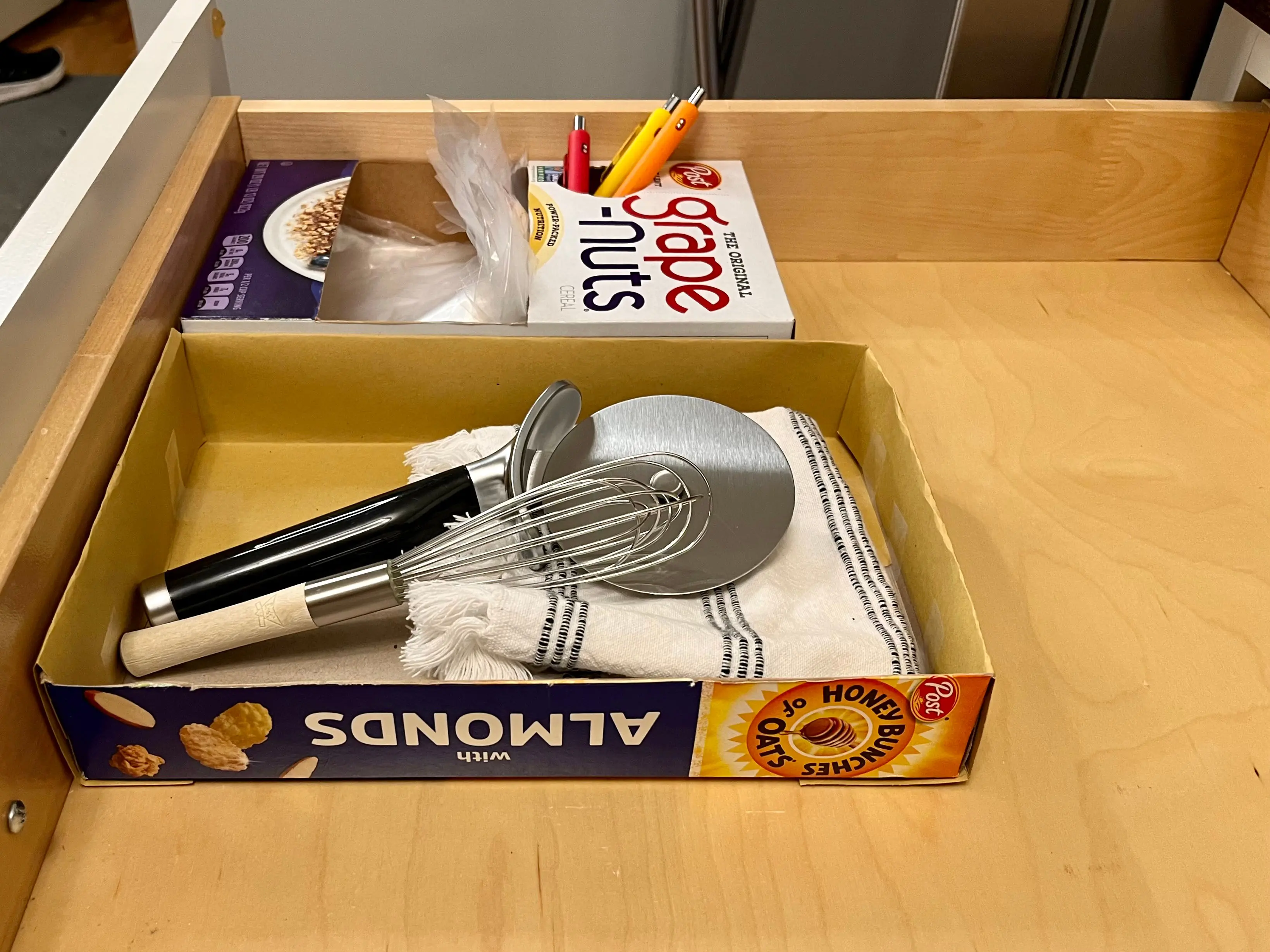 A box of Honey Bunches of Oats with Almonds that is cut in half and sitting in a drawer.