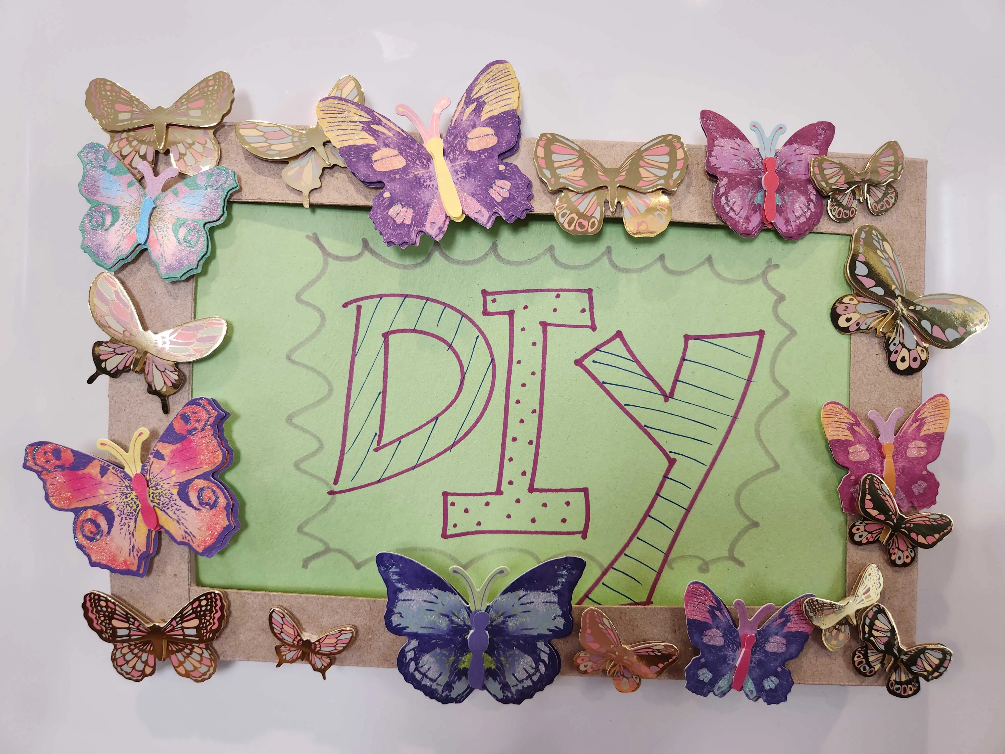A piece of art that says DIY with butterflies on its edges.