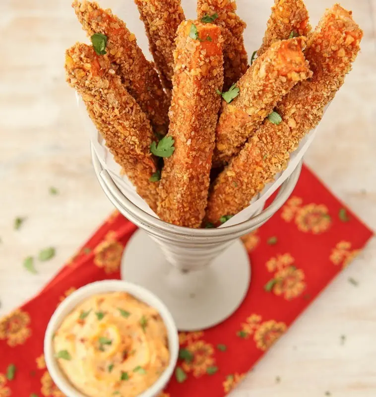A thanksgiving side dish of sweet potato fries with a small bowl of Aioli on the side.